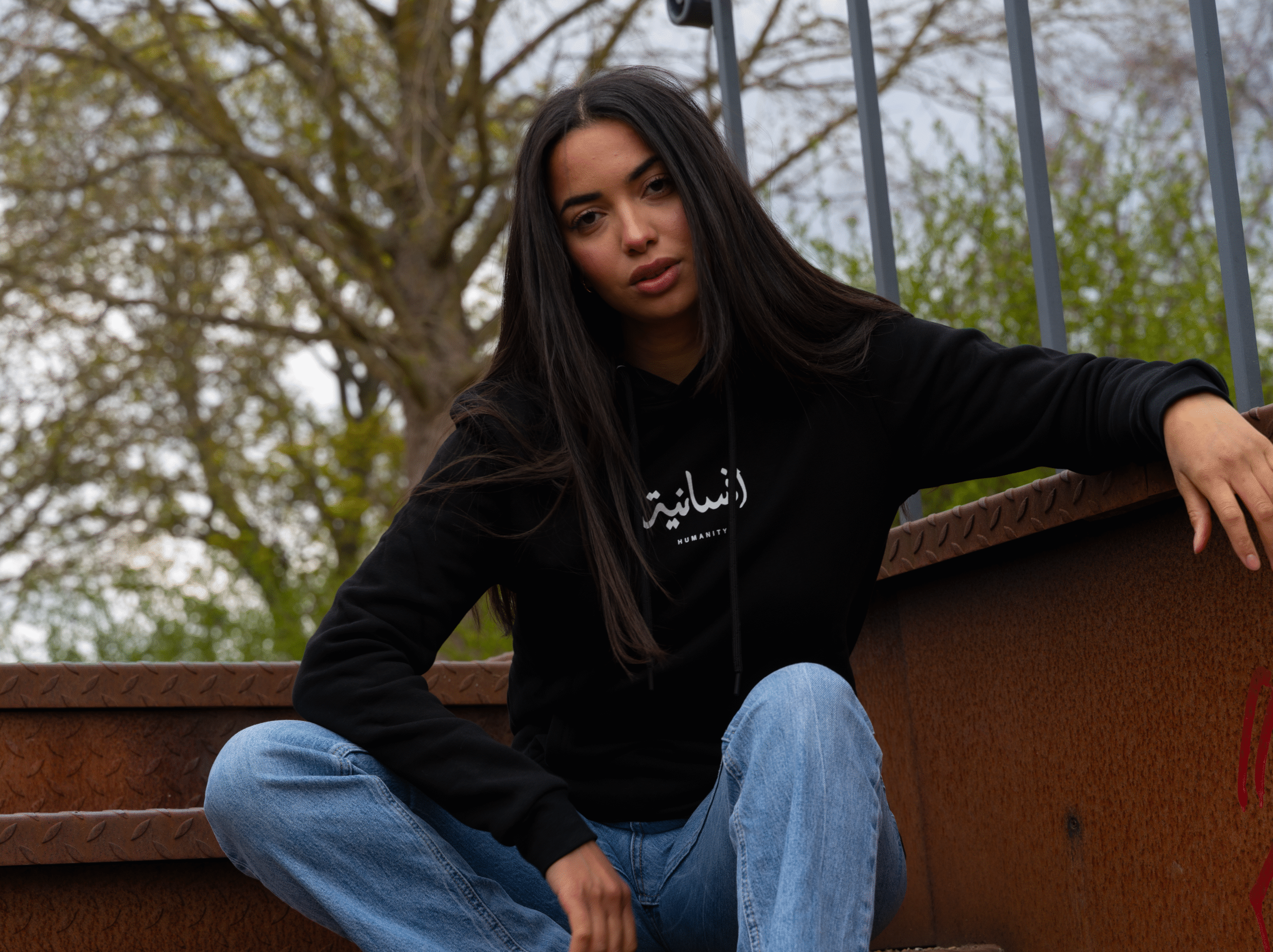 Model wearing black Le Rêve hoodie outdoors